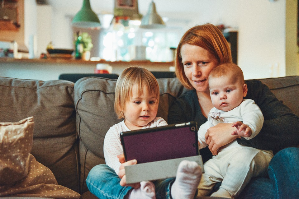 Woman and children watching electronic device